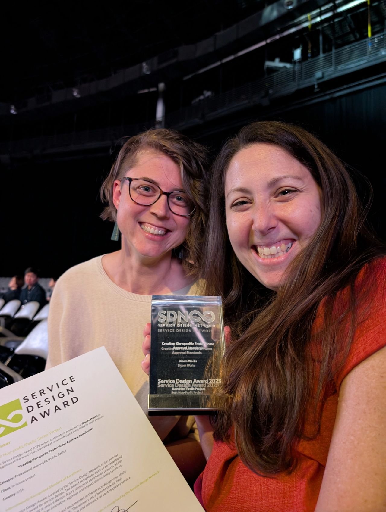 Hannah Herrington and Katrina Lanahan holding up a Service Design Award