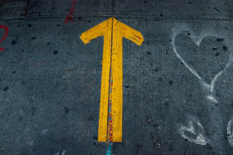 Photo of a yellow arrow painted on the ground by @jontyson on Unsplash