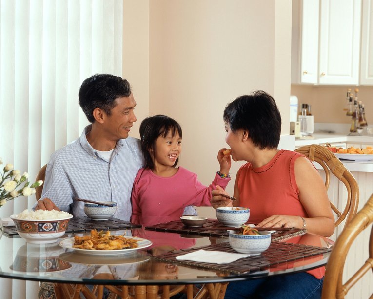 A family with a young child eating dinner