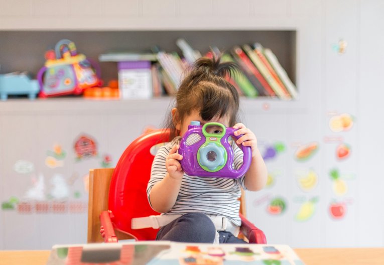 A young girl holding a toy camera